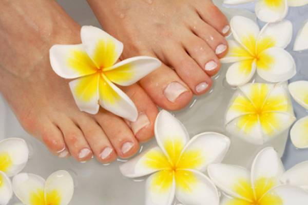 Freshly manicured feet in a flower bath
