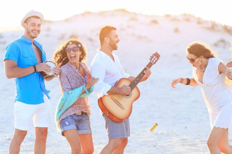 Friends playing guitar on the beach