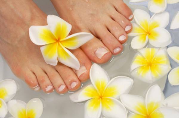 Freshly manicured feet in a flower bath