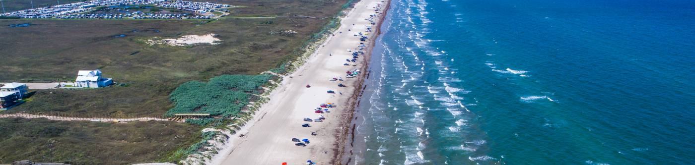 view of port aransas beach from above with cars parked on the sand